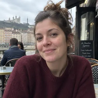 Portrait de Maëlle Ruaux, femme d'une trentaine d'années aux cheveux châtains et pull bordeaux
